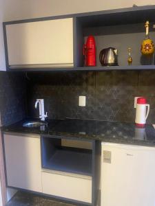 a kitchen with a sink and a counter at Segunda Casa- Seu cantinho na Praia do Morro em Guarapari - Quartos suítes 2 até 4 pessoas in Guarapari