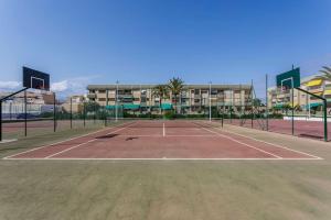 un court de tennis en face d'un bâtiment dans l'établissement Apto. primera línea playa, Retamar, Cabo de Gata (1º), à Retamar