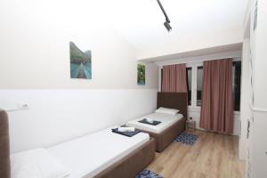 een woonkamer met een bank en een bed bij Cityscape Delight in Shkodër