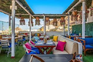 a patio with tables and chairs on a roof at Taylor 203 @ Morgan Residences in Cabo San Lucas