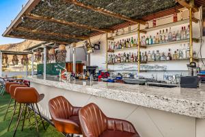 a bar with a row of bar stools at Taylor 203 @ Morgan Residences in Cabo San Lucas