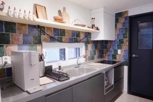 a kitchen with a sink and a microwave at Blue Casa in Seogwipo