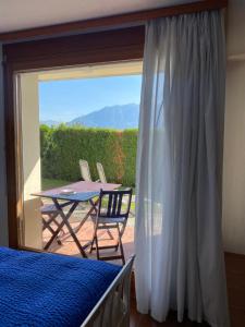 Schlafzimmer mit einem Balkon mit einem Tisch und Stühlen in der Unterkunft Casa Vignole-Badasci in Orselina