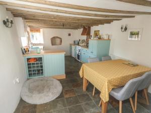a kitchen and dining room with a table and chairs at Brewers Cottage in Kings Nympton