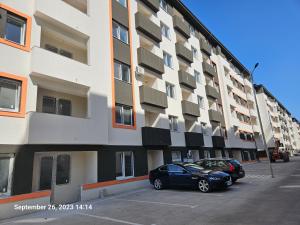 two cars parked in a parking lot in front of a building at Garsoniera Residence Militari in Chiajna