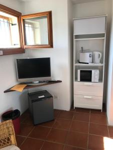 a room with a computer monitor and a microwave at Casa Vignole-Badasci in Orselina