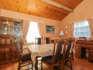 een eetkamer met een tafel en stoelen en een piano bij Rose Cottage in Swanage