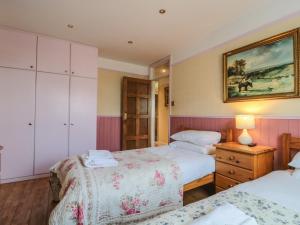 a bedroom with two beds and a painting on the wall at Rose Cottage in Swanage