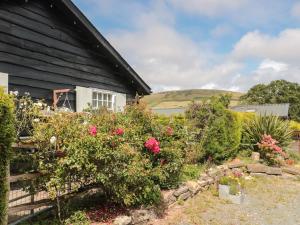 a garden next to a house with flowers at Rose Cottage in Swanage