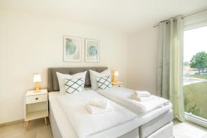 una camera da letto bianca con un letto grande e una finestra di Apartment "Sonnenlaune" a Garz
