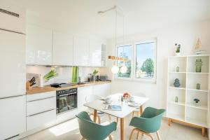 cocina blanca con mesa y sillas en Apartment "Sonnenlaune" en Garz-Usedom
