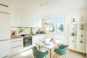 una cucina bianca con tavolo e sedie di Apartment "Sonnenlaune" a Garz Altre 20 foto