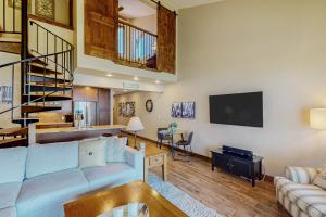 uma sala de estar com um sofá e uma televisão em Lake Chelan Shores: Sandy Beach Delight #1-5 em Chelan