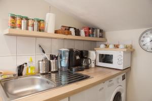 a kitchen counter with a sink and a microwave at Spacious 2-Bedroom Family Duplex with Free Parking and Netflix in Bordeaux +15 photos
