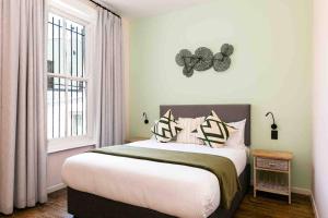 een slaapkamer met een groot bed en een raam bij The Palm Flats - Palm Paradise in Kaapstad