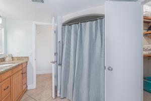 a bathroom with a shower with a shower curtain at Renovated Condo Offering Free Beach Access!! in Marco Island +17 photos