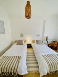 two beds sitting next to each other in a room at Bright modern 3 BR in Portimao downtown in Portimão