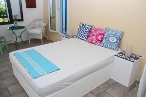 ein weißes Bett mit Kissen auf dem Zimmer in der Unterkunft Ladanos Apartment Thassos in Kallirákhi