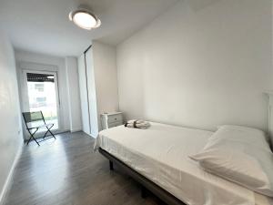 a white bedroom with a bed and a chair at PUSHE Playa Granada Beach & Golf 21 in Motril +37 photos