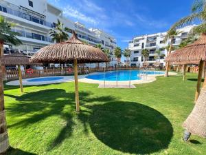 un complexe avec une piscine bordée de parasols dans l'établissement PUSHE Playa Granada Beach & Golf 21, à Motril