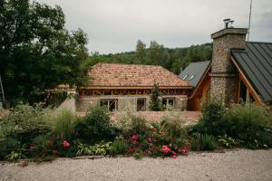una casa de piedra con un jardín delante de ella en PurpleVague, 