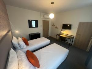 シャルルヴィル・メジエールにあるLa Grande-Ourseのベッド2台と机があるホテルの部屋 +16枚の写真