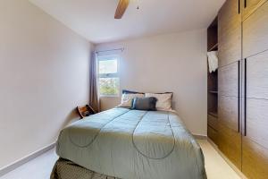 a bedroom with a large bed and a window at Rainbow Fish Hideaway @ TAO Santamar E201 in Akumal