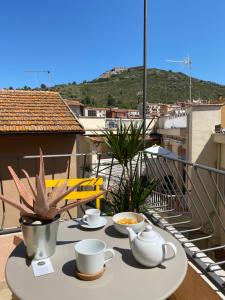 een tafel met kopjes en schotels op een balkon bij Loraia Design Rooms in Porto Ercole