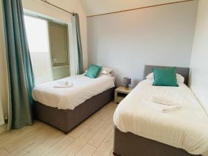 two beds in a room with a window at Olympic Village Home - Victory in Portland