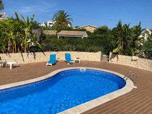 a swimming pool with two blue chairs and a swimming pool at Cama da Vaca in Mato Porcas