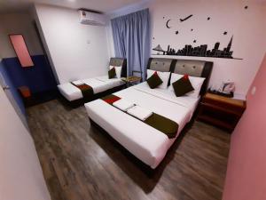 a bedroom with two beds with white sheets at Good2Stay Hostel in Melaka