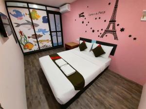 1 dormitorio con 1 cama y la torre Eiffel en Good2Stay Hostel en Melaka