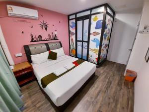a bedroom with a bed with a pink wall at Good2Stay Hostel in Melaka