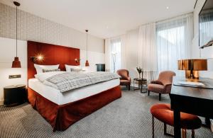 アンダーナッハにあるHotel am Ochsentorのベッドとデスクが備わるホテルルームです。