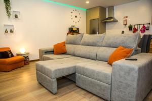 a living room with a gray couch and orange pillows at TOURAL HOUSE Villa in Arcos de Valdevez
