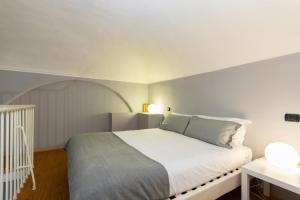 トリノにあるQuadrilatero District! Piazza Consolata Modern Loftのベッドルーム1室(白いベッド1台、アーチ型のベッド付)