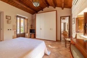 a bedroom with a large white bed and a table at Il Flauto Magico in Modica