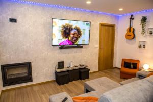 a living room with a tv on a wall at TOURAL HOUSE Villa in Arcos de Valdevez