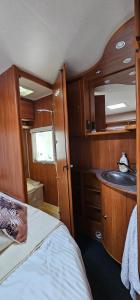 a bathroom with a sink and a bed in a boat at Campervan romantic getaway in Old Town Brasov in Braşov