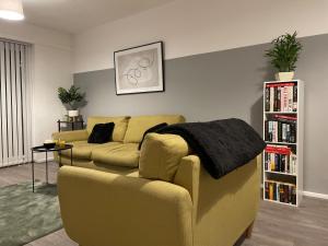 a living room with a couch and a book shelf at Modern House with Fast WIFI & FREE Parking - Recently Refurbished - Contractor Friendly by IRWELL STAYS in Cronton