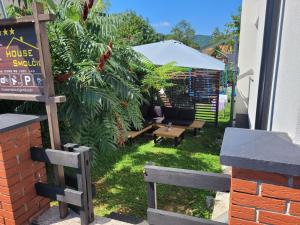 a patio with a table and benches in the grass at House Smolčić in Otočac