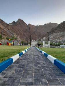 a cobblestone road with blue and white at Jeema lodge in Hatta