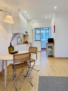 una cucina e una sala da pranzo con tavolo e sedie di Bright modern 3 BR in Portimao downtown a Portimão