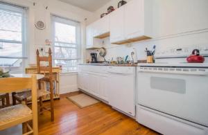 cocina con electrodomésticos blancos, mesa y comedor en Luxury 5BR Apartment in NYC! en Nueva York