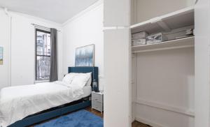 a white bedroom with a bed and a window at Luxury 5BR Apartment in NYC! in New York
