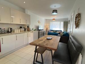 a kitchen and living room with a wooden table at Olympic Village Vela - Portland in Portland