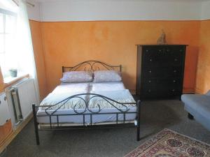 a bedroom with a bed and a black dresser at Ferienwohnung im grünen Elbtal in Stadt Wehlen
