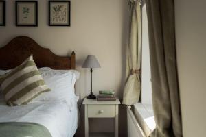 um quarto com uma cama e uma mesa com um candeeiro em The Walled Garden em Totnes