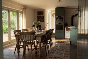 a kitchen with a wooden table and chairs in a room at The Walled Garden in Totnes +39 photos