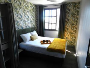 - une chambre avec un lit doté d'une fenêtre et d'un plateau dans l'établissement Les jardins de la rivière, à Saint-Denis